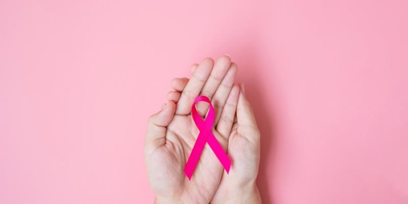 Cáncer de mama - Foto: Envato Elements Manos con lazo contra el cáncer de mama