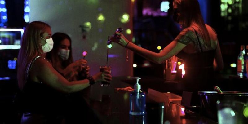 Ocio nocturno Grupo de jóvenes con mascarilla en un local nocturno / El Mundo