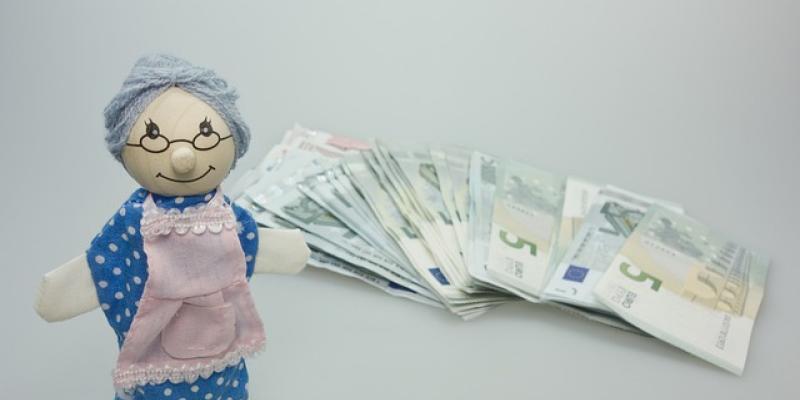 Imagen que simboliza la paga extra de verano de los pensionistas / Pixabay Muñeco de una abuelita pensionista con el dinero de la paga extra de verano