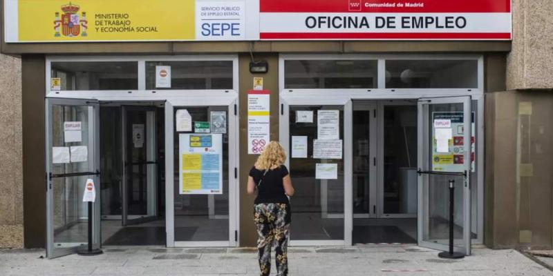 Una mujer en frente de una oficina de empleo 