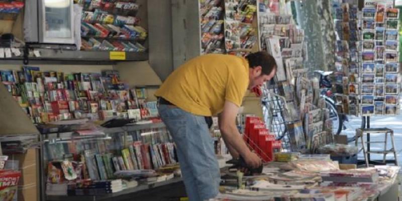 Un quiosquero preparando el expositor de prensa. Sube el paro en el mes de mayo pero frena su avance.