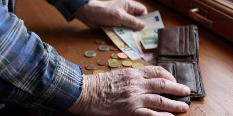 Manos de una persona mayor contando su dinero de la pensión de jubilación