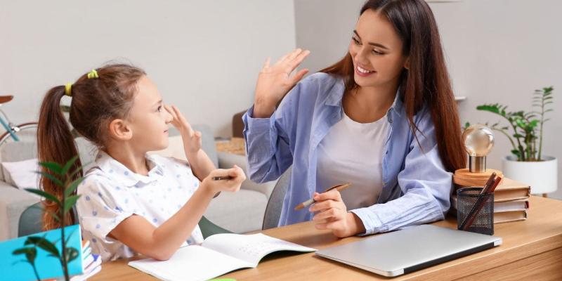 Chica chocando los cinco a una niña con pérdida auditiva
