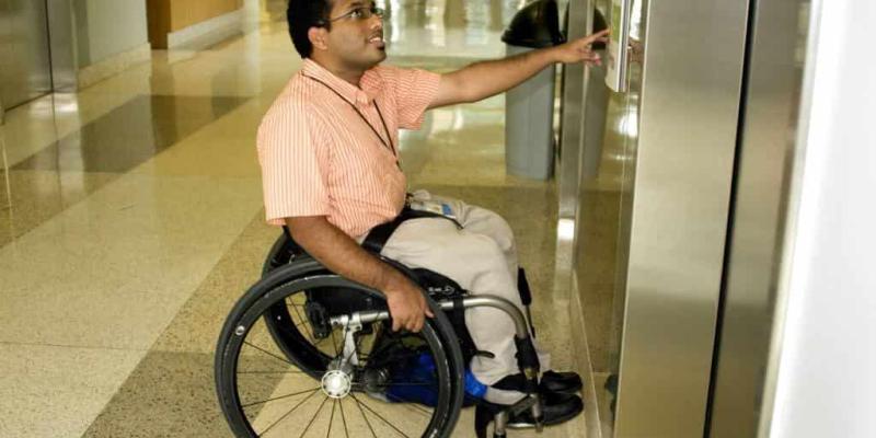 Imagen de una persona en silla de ruedas en un ascensor/Dictator Características para contar con ascensores accesibles