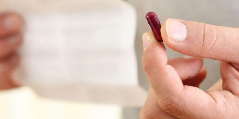 Prospectos medicamentos más fáciles Persona tomando medicamentos mientras lee un prospecto / Foto: Bigstock