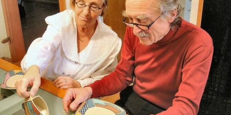 Dos personas mayores de sesenta tomando café en su casa