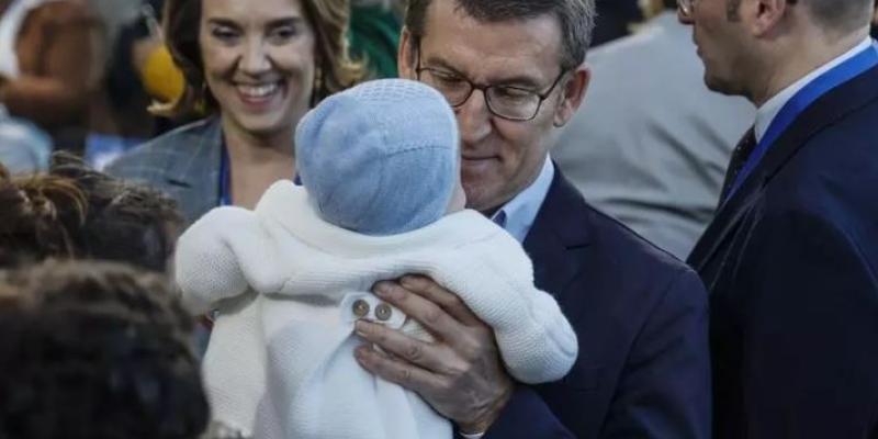 Feijóo coge un bebé en brazos durante la Intermunicipal del PP en Valencia el 4 de febrero. 