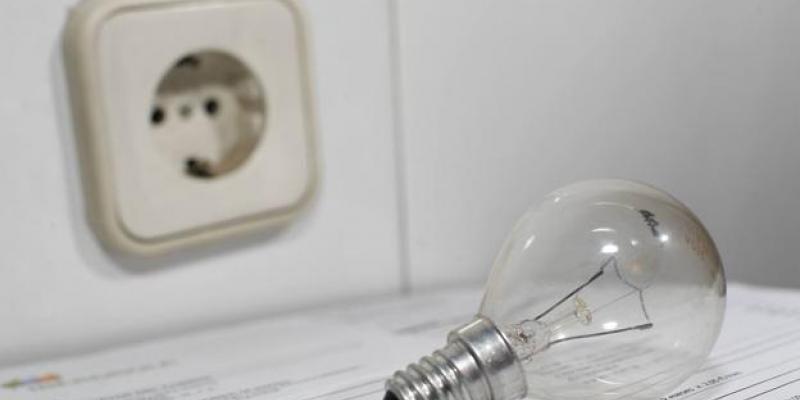 ¿Cómo me afecta la nueva subida en la factura de la luz? Bombilla y enchufe junto a una factura de electricidad