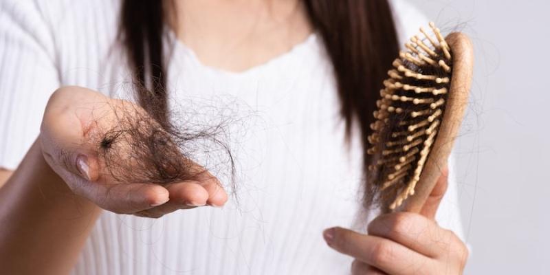 Imagen de una chica con un cepillo de pelo/Riscell Caída del pelo en primavera