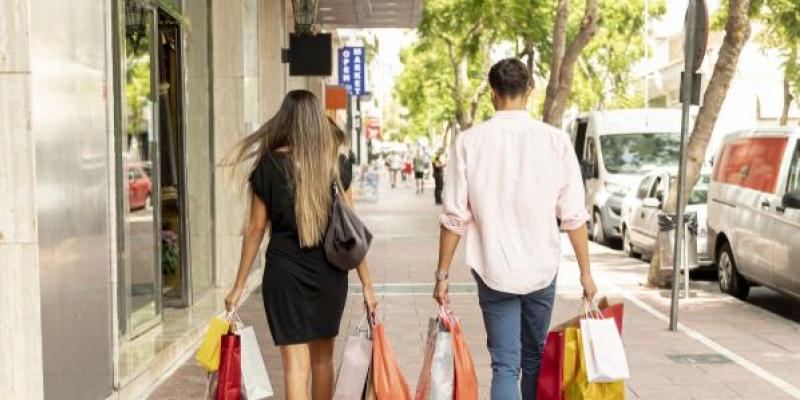 Una pareja, paseando con bolsas de compra de rebajas 