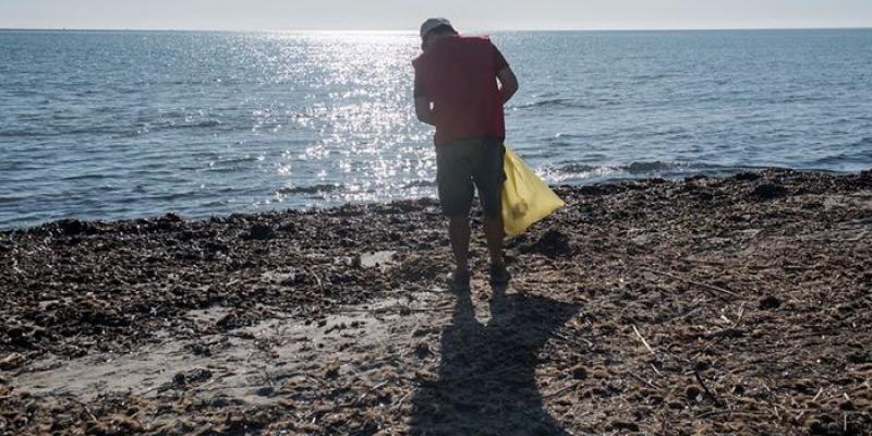 Voluntario recogiendo basuraleza en un playa española