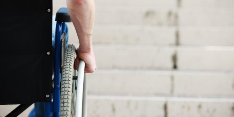 Accesibilidad | Foto de 123RF/stokkete Persona en silla de ruedas ante una escalera