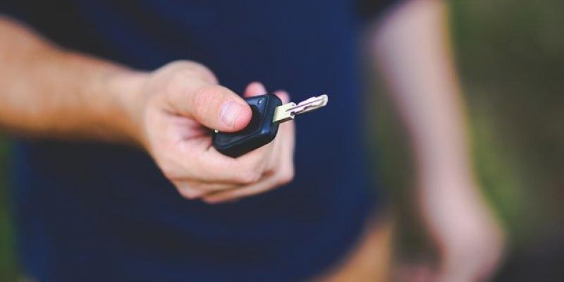 Hombre sosteniendo una llave de coche