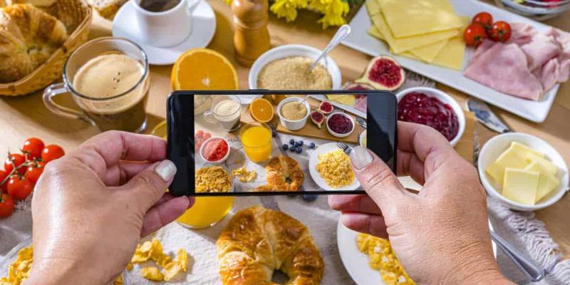 Imagen de una persona echando una foto a la comida/La Vanguardia El horario de las comidas sí influye en la salud cardiovascular