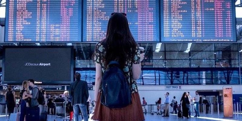 Chica observando las pantallas de los vuelos en un aeropuerto