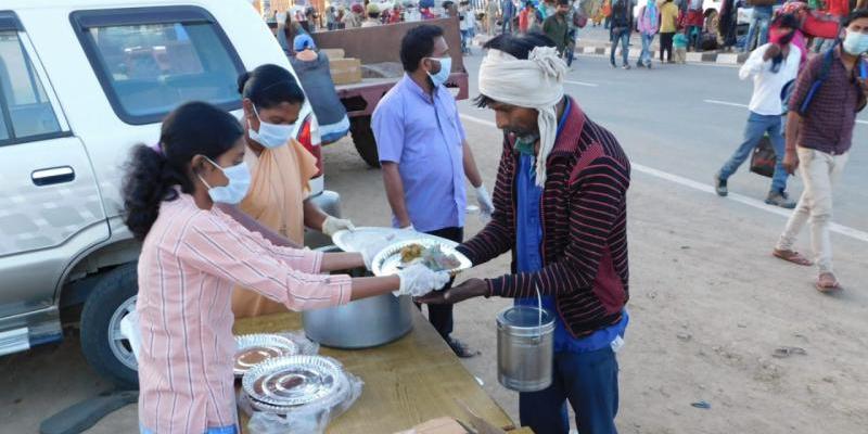 Personas comiendo en la calle en India | Foto: Manos Unidas