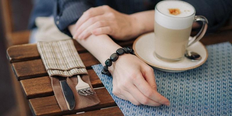 Mujer tomando un café junto a su portátil