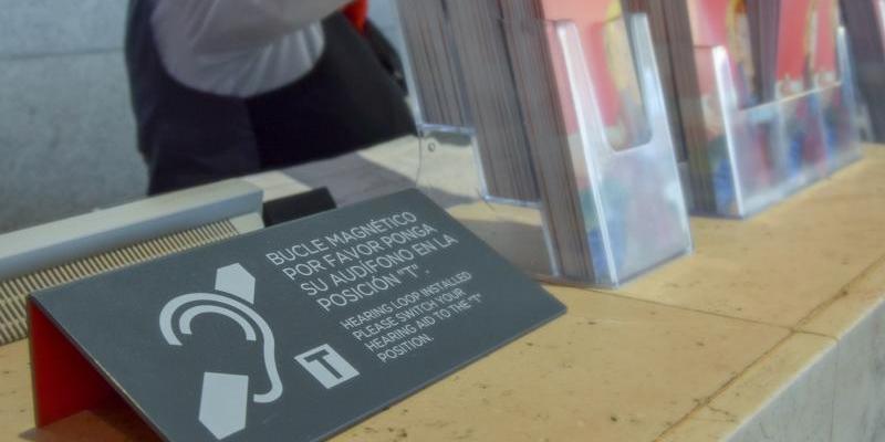 Las personas sordas también pueden disfrutar de los museos Uno de los mostradores del Museo del Prado con un cartel informativo sobre bucle magnético, foto de Museo del Prado