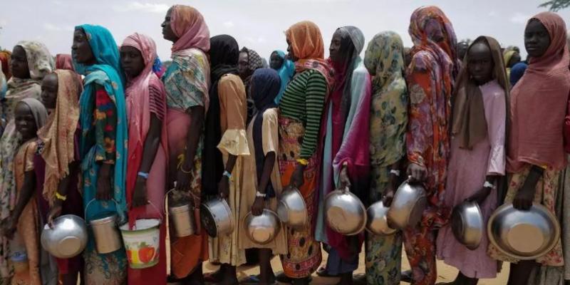 Mujeres sudanesas esperan para recibir arroz en Chad, tras huir de Sudán 