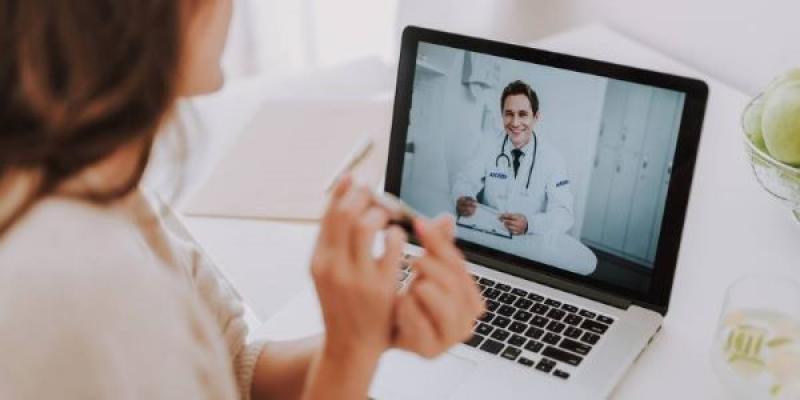 Pantalla de un ordenador en el que se ve a un doctor hablando  con una paciente 