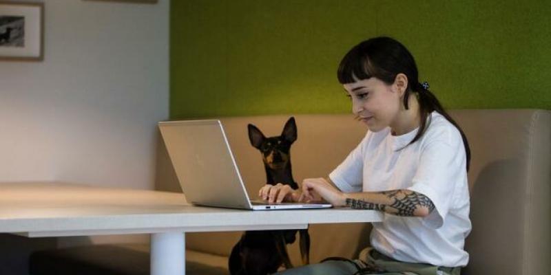 Una mujer trabaja desde su casa acompañada de su mascota