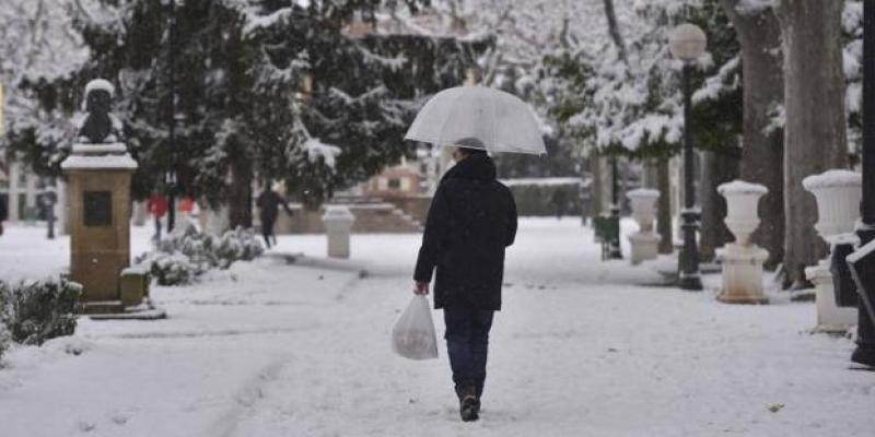 Un hombre pasea con paraguas por la nieve tras el paso de la borrasca Filomena, en Huesca. 