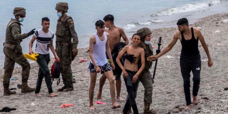 Menores llegando a las playas de Ceuta mientras son recibidos por miembros del Ejército.