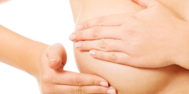Una mujer haciéndose una autoexploración en la mama