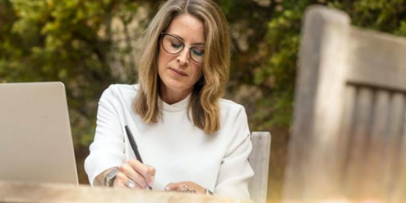 Mujer escribiendo en su jardín