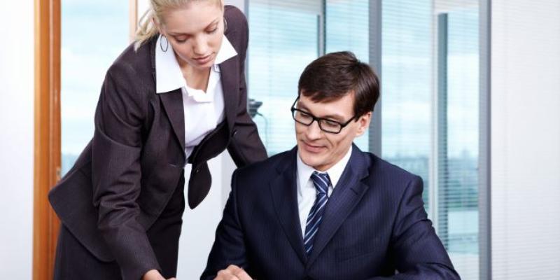 Dos personas firmando un documento