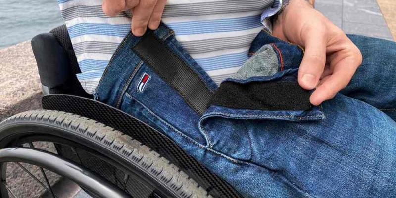 Tommy Adaptive Persona en silla de ruedas vistiendo un pantalón adaptado de Tommy Adaptive