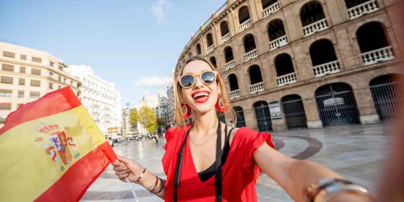 Imagen de una turista con una bandera de España/Envatoelements Gastos de los turistas extranjeros en España