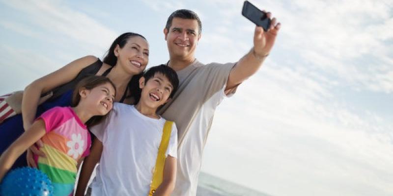 Imagen de una familia echándose una foto/Bekia Padres Cómo guardar tus fotos en familia en el ordenador