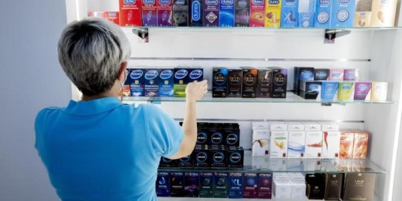 Los preservativos ya no se usan Dependienta colocando preservativos en el espositor