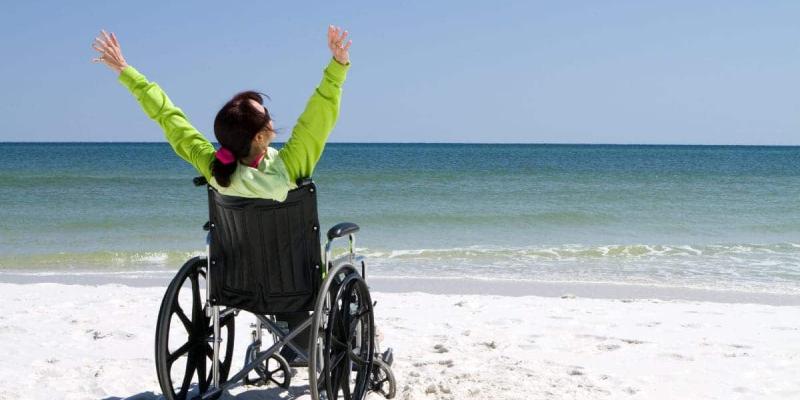 Imagen de una persona en silla de ruedas en la playa/Tododisca Viajes del Imserso