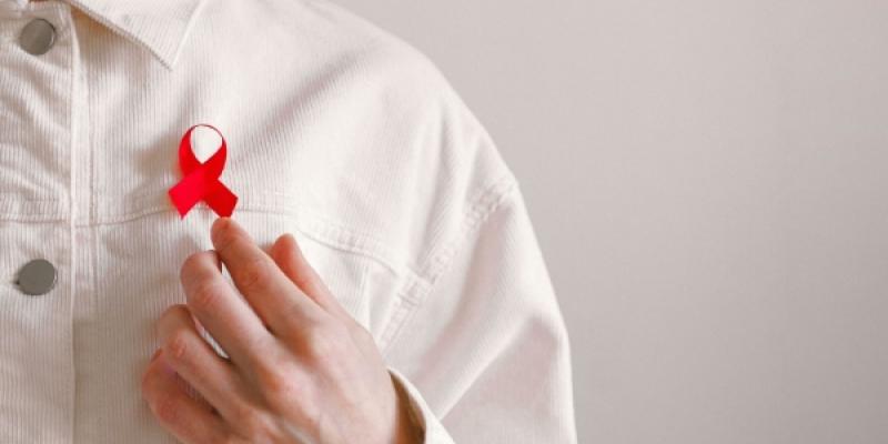 Imagen del pecho de una persona donde puede verse un lazo a favor de la lucha contra el VIH