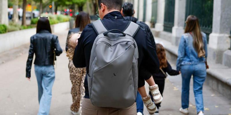 Fotografía de archivo de una familia recorriendo el paseo del Prado (Madrid). 