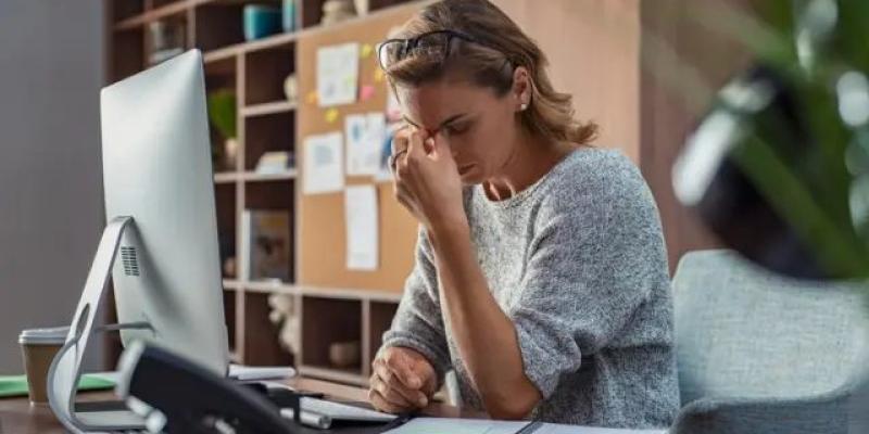 Una de los síntomas del déficit de b12 es el cansancio. / iStockphoto Mujer cansada frente a un ordenador