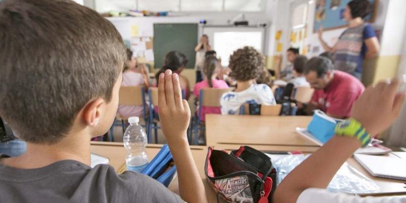 Niño levantando la mano en la Vuelta al cole