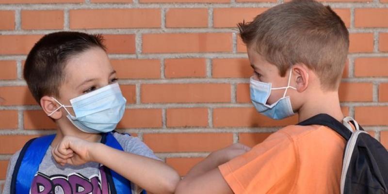 Dos niños saludándose en la vuelta al cole