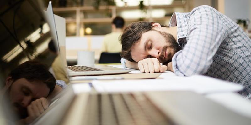 Chico durmiendo con un portátil de conexión WiFi lenta