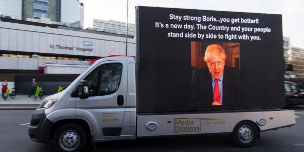 Una furgoneta pasea un mensaje de ánimo a Boris Johnson frente al hospital donde está ingresado