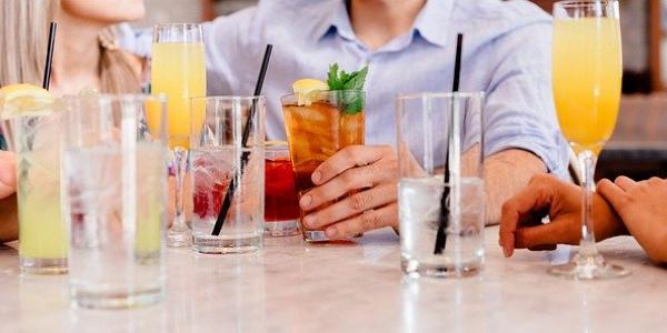 Mesa con varios vasos de bebidas alcohólicas