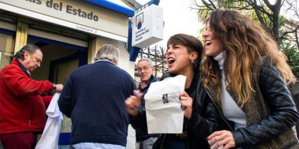 Un grupo de personas celebran en San Lorenzo de El Escorial el segundo premio del Sorteo Extraordinario de la Lotería de Navidad que ha correspondido al número 10.989, dotado con 1.250.000 euros a la serie, por lo que el poseedor de cada décimo ganará 125.000 euros. EFE