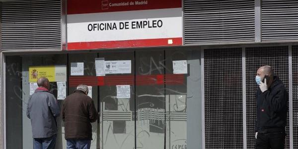 Dos personas leen los carteles de una oficina de empleo cerrada, el pasado lunes. 