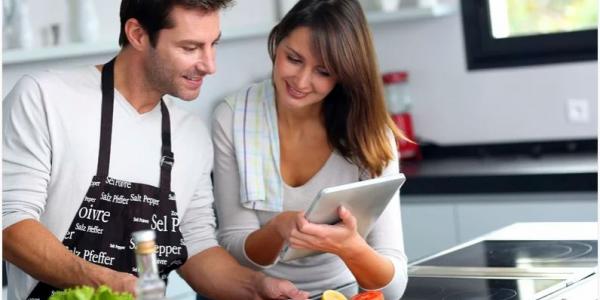 Dos personas cocinando y buscando recetas por internet