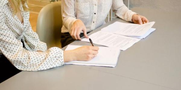 Dos personas firmando unos papeles