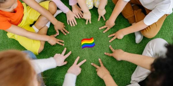 Niños señalando una bandera LGTBI