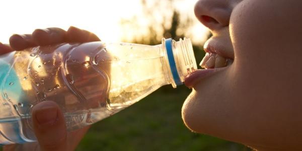 Persona bebiendo agua embotellada