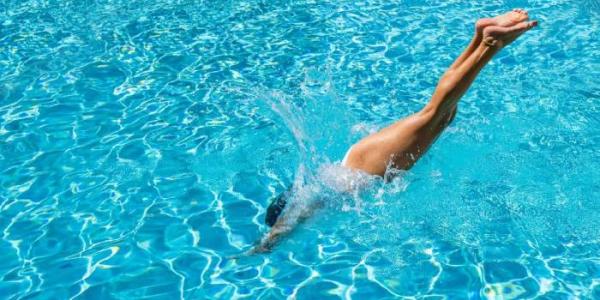 Mujer tirándose de cabeza a la piscina